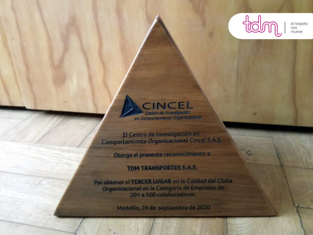 Trofeo triangular de madera otorgado a TDM Transportes S.A.S. por Cincel S.A.S. en 2020, con logotipos visibles.