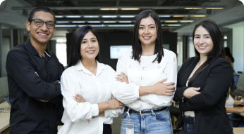 Cuatro personas de pie con los brazos cruzados, sonriendo en un entorno de oficina.